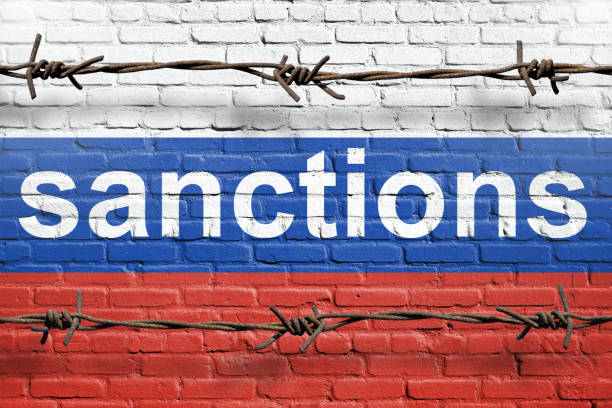 Flag of Russia painted on a brick wall with word sanctions stock photo