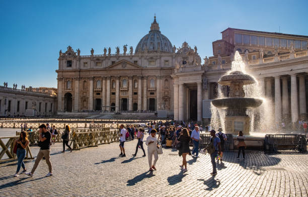 St. Peter square with St. Peter Basilica and historic fountain in Vatican city district of Rome in Italy stock photo