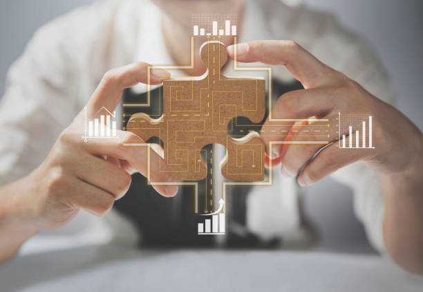 Businessmen connect jigsaw puzzles to market strategies and economic growth charts. business strategy stock photo