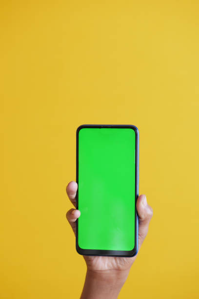 istock Close up of young man hand using smart phone with green screen 1385327346