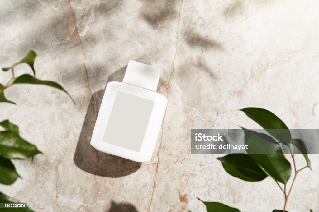 Face or body care cosmetic product bottle with blank label on marble Flat Lay Stock Photo