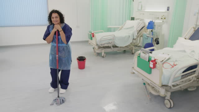 Portrait confident female orderly mopping hospital floor