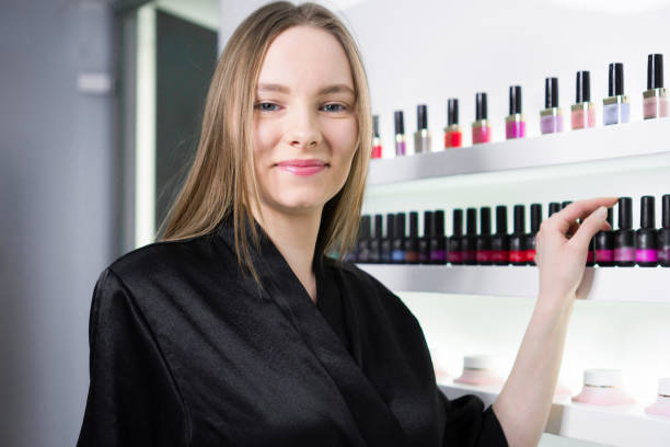 istock Smiling woman choosing nail polish color 1385328546