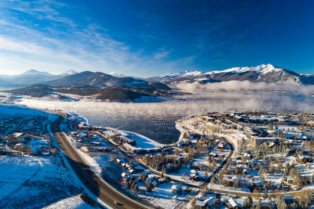 Snowcapped Colorado Rocky Mountains With Lake And Snow Covered Neighborhood Snowcapped Colorado Rocky Mountains in the distance during sub-freezing temperatures with an aerial of Dillon Reservoir and the town of Dillon in the foreground. summit county stock pictures, royalty-free photos & images