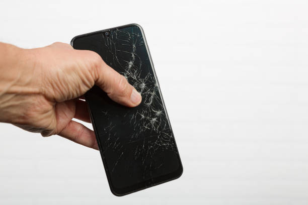 istock Hand showing a smart phone with cracked display 1385340839