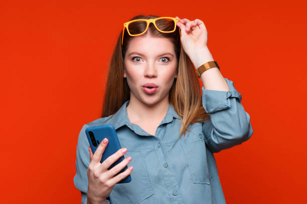 istock Girl in glasses with mobile phone in studio 1385342986