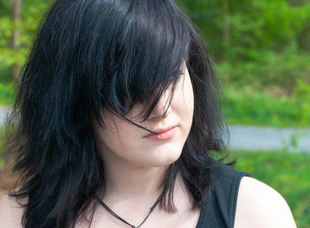 Emo gothic girl looking away, close-up Gothic emo woman with black hair and black clothes, looking away, close-up black hair emo girl stock pictures, royalty-free photos & images