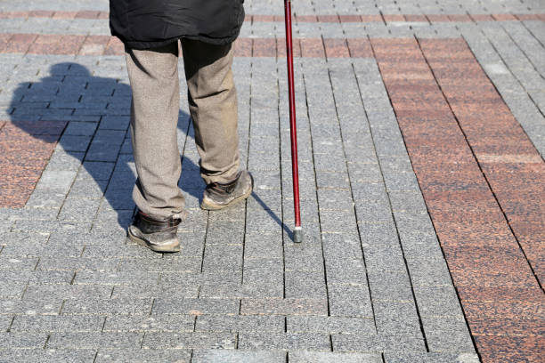istock Old man walking with a cane down the street 1385359278