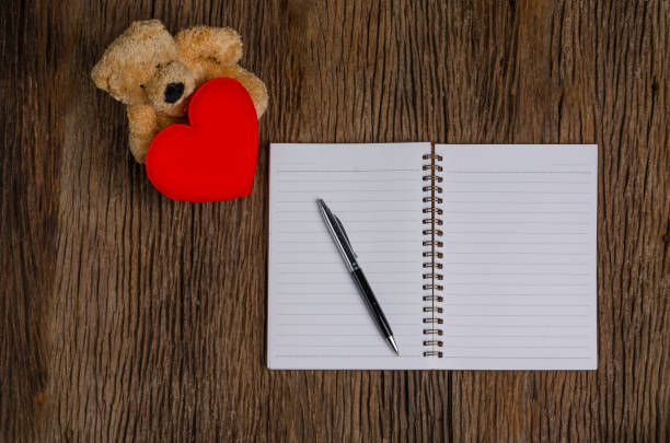 Romantic setting of handwritten declaration of love surrounded by colorful paper hearts on a rustic wooden table captures sentiment and affection