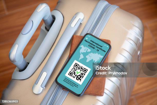 Phone With International Vaccination Certificate Covid 19 Background Suitcase Stock Photo - Download Image Now