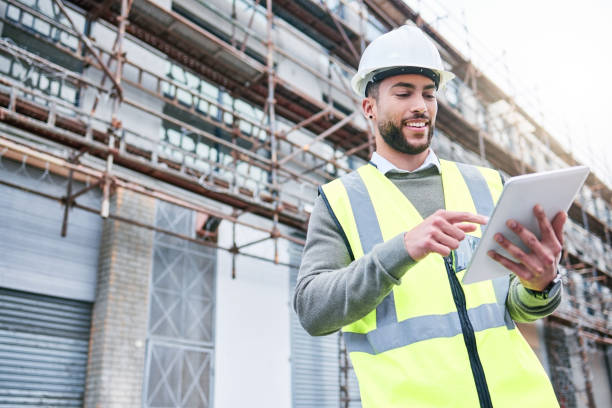 istock Shot of a handsome male construction worker using a tablet while standing outside 1385368222