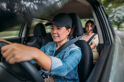 Female rideshare driver and female passenger riding on the road.