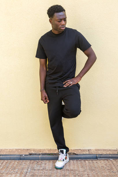 istock Thoughtful young black man leaning on wall and looking away 1385379992