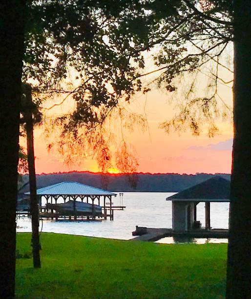 istock Bright orange sunset over a lake scene 1385380755