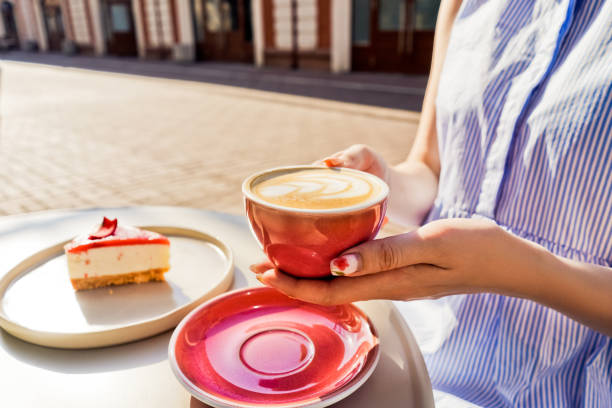istock Cup of latte coffee in womans hands. 1385381936