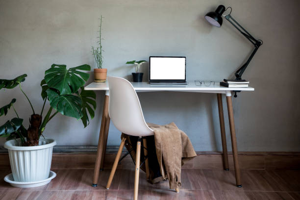 istock Home office with laptop mockup and chair, glasses document book on table decor as lamp light and monstera tree pot plants house nature wall modern loft interior decorations workspace. 1385382749