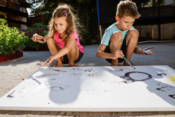 istock Children painting outdoors 1385384145