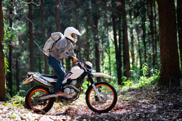 ein mann, der ein offroad-motorrad auf einer bergstraße fährt - motocross leisure activity sport motorcycle racing stock-fotos und bilder