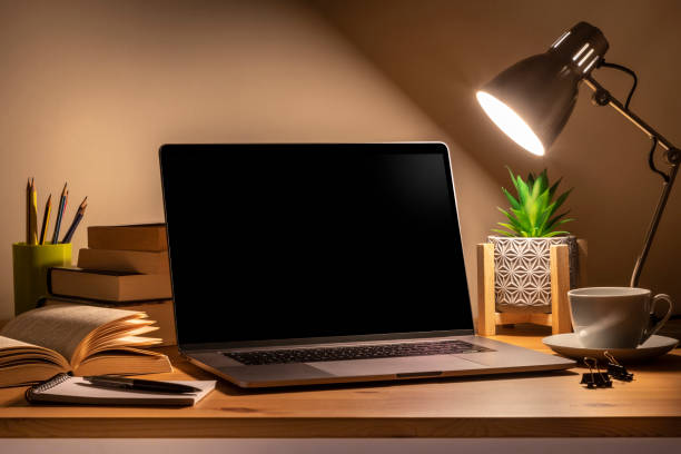 istock Home desk at night with copy space on laptop screen 1385390290