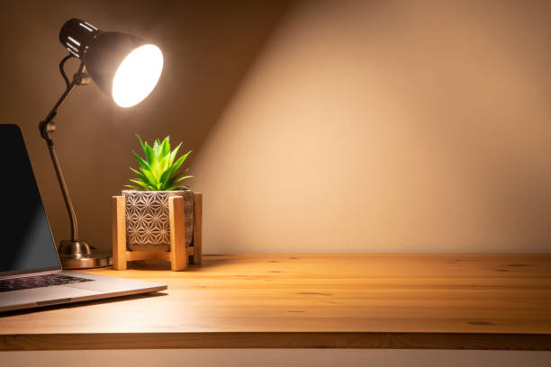 istock Wooden desk at night with copy space 1385390297