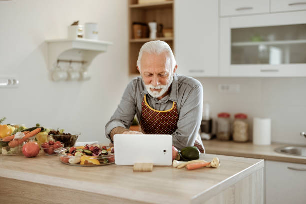 istock Senior Man Reading Recipe on Tablet 1385392618
