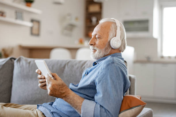 istock Senior man with Headphones and Digital Tablet 1385394560