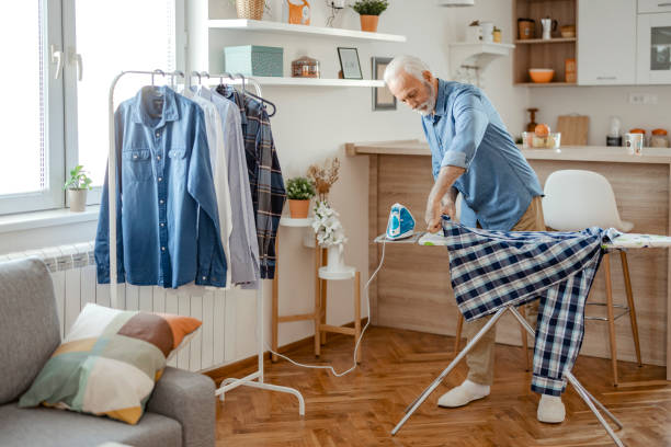 istock Senior Man Ironing Shirt 1385394656