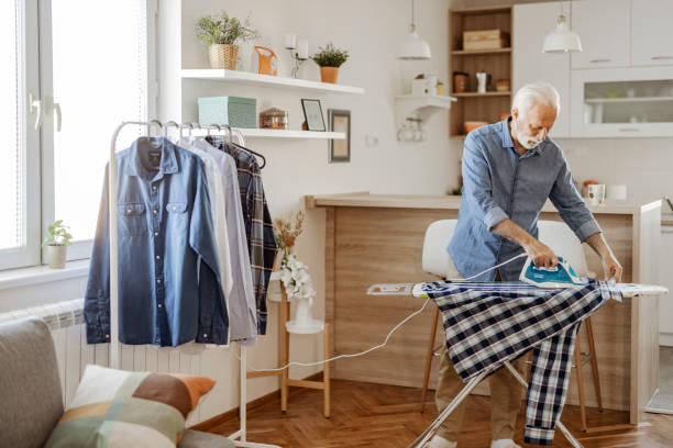 istock Senior Man Ironing Shirt 1385395250