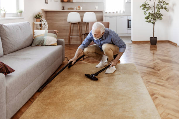 istock Senior Male Cleaning House using Vacuum 1385395763