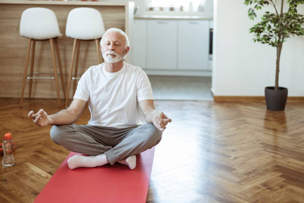 senior fitness mann macht meditation - floor women sitting yoga stock-fotos und bilder