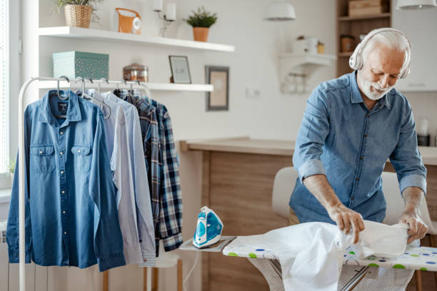 istock Senior Man Listening to Music while Ironing 1385400245