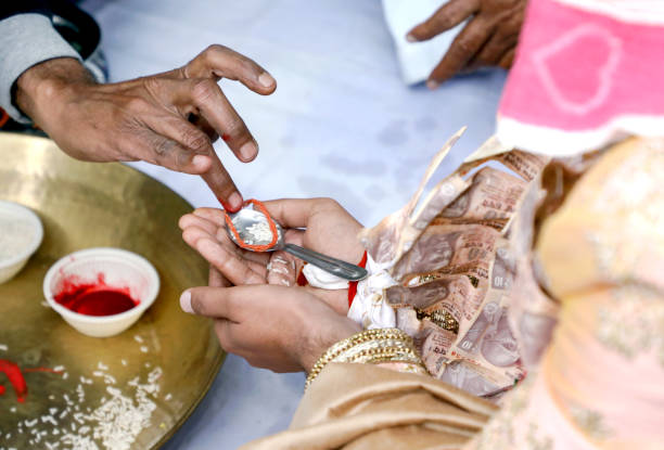 istock Indian groom performing rites holding some rice in his mehndi designed hands during wedding ceremony. 1385402463