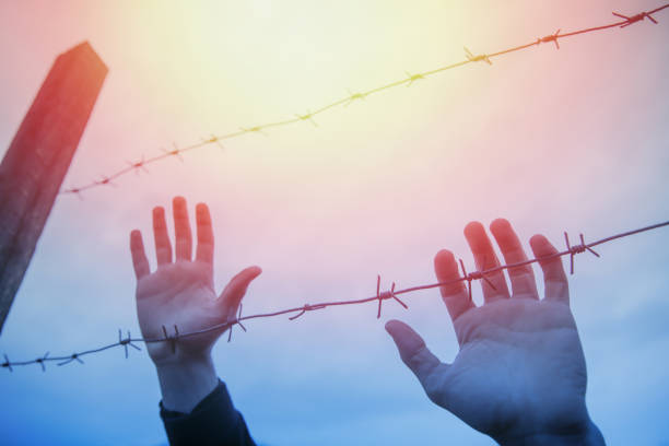 istock Refugee men and fence 1385402575
