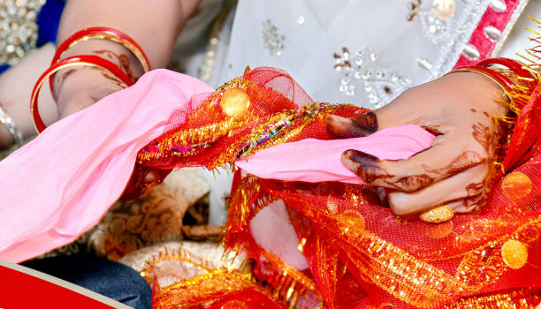 istock Indian bride and groom during Gath Bandhan ritual ceremony 1385402752