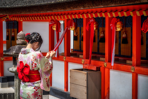 29 march 2019 - Kyoto, Japan: Young Woman Praying at fushimi inari taisha Temple, Kyoto, Japan