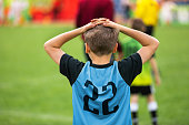 Disappointed Soccer Boy on Football Game. Kid Putting Hands on His Head After Loosing Goal