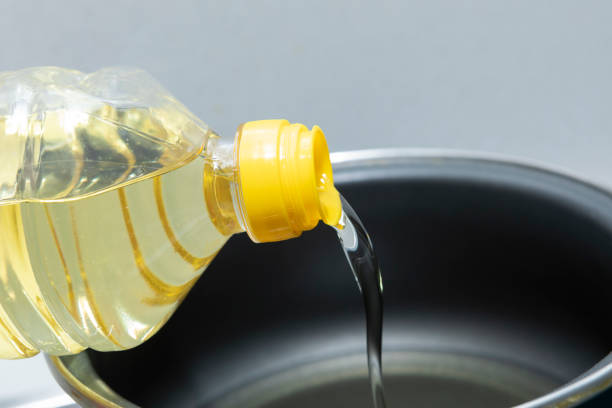 Sunflower oil, being poured into a cooking pot stock photo