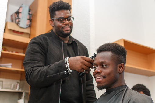 Young African man getting his haircut at a barber shop
