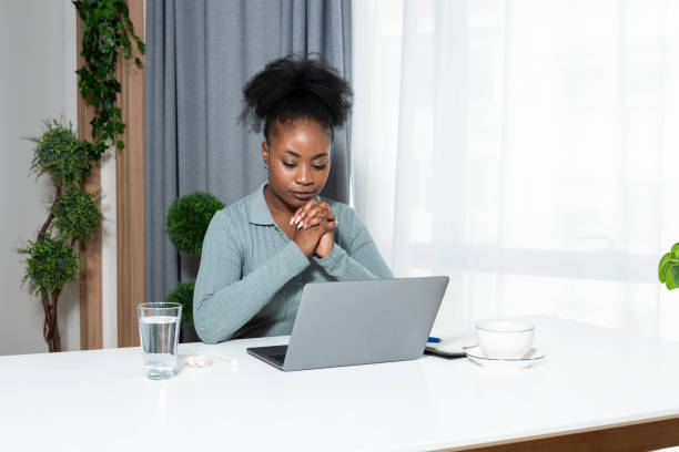 jeune blogueuse afro-américaine concentrée et militante des droits de l’homme écrivant un blog sur la cyberintimidation et le racisme chez les jeunes à travers son expérience négative personnelle. - emotional stress ideas bullying office photos et images de collection