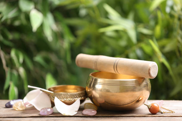 istock Composition with tibetan singing bowl and different gemstones on wooden table outdoors. Sound healing 1385411940