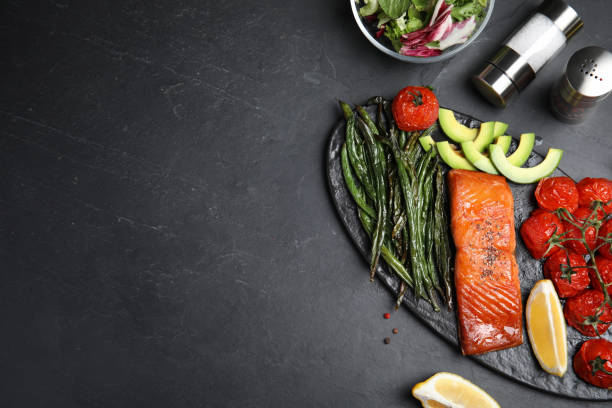 Tasty cooked salmon and vegetables served on black table, flat lay with space for text. Healthy meals from air fryer