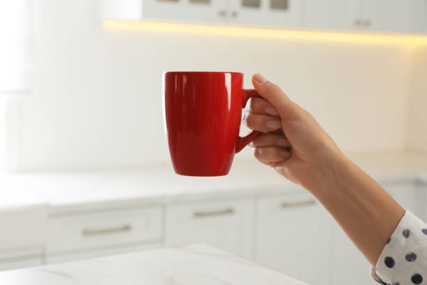 istock Woman with red cup at home, closeup 1385413870