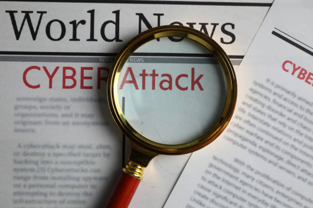 istock Newspaper with headline CYBER ATTACK and magnifying glass, top view 1385414985