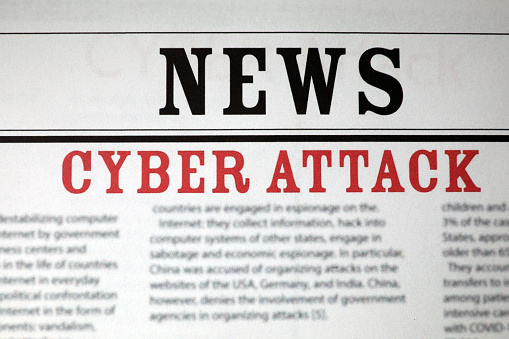 Top view of newspaper with headline CYBER ATTACK as background, closeup