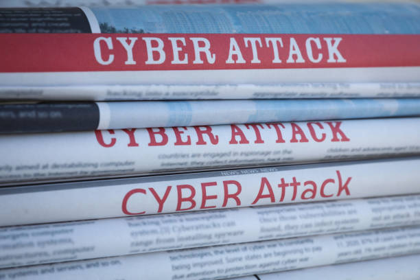 istock Stacked newspapers with headlines CYBER ATTACK as background, closeup 1385415052