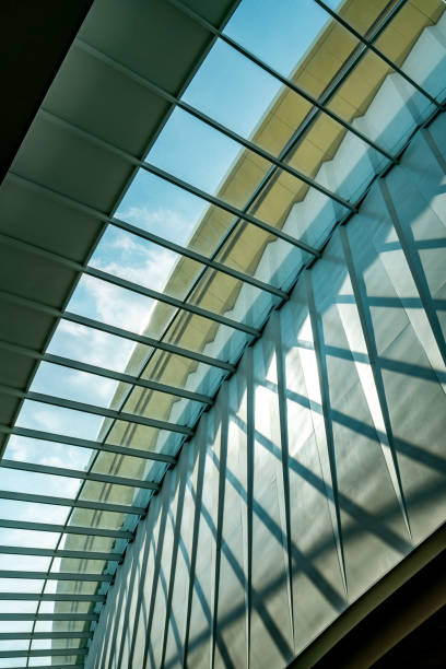 istock Abstract pattern of building structure of glass ceiling, light, and shadow, worm eye view image, daylight from sky, vertical image. 1385417711