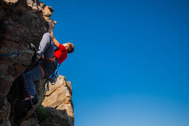 istock Strong male climber hanging by a cliff 1385418348