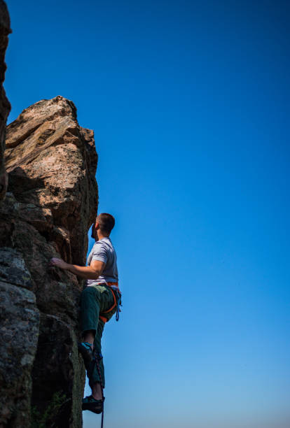 istock Man climbing a very steep mountain -Rock Climbing 1385418382