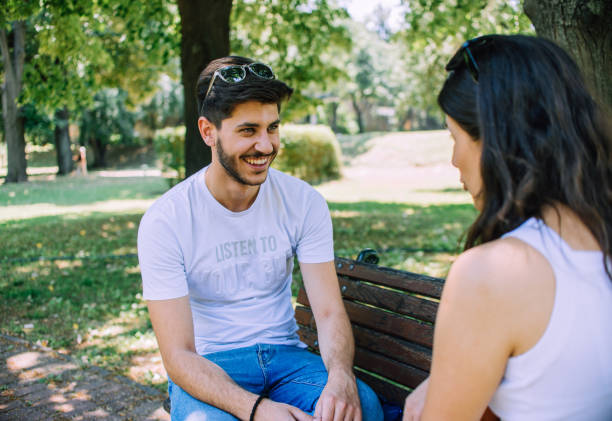 istock Dating couple sitting on bench 1385419042