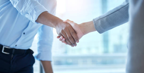 istock Shot of two unrecognizable businesspeople shaking hands at work 1385421040